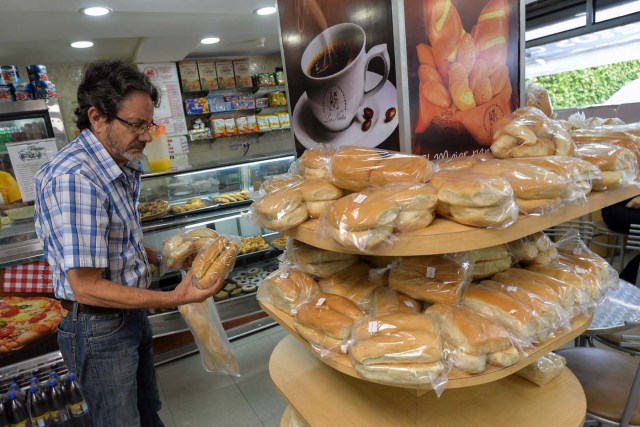 A man buys bread at a bakery, on June 6, 2017 in Caracas, Venezuela. / AFP PHOTO / LUIS ROBAYO / TO GO WITH AFP STORY by ALEXANDER MARTINEZ