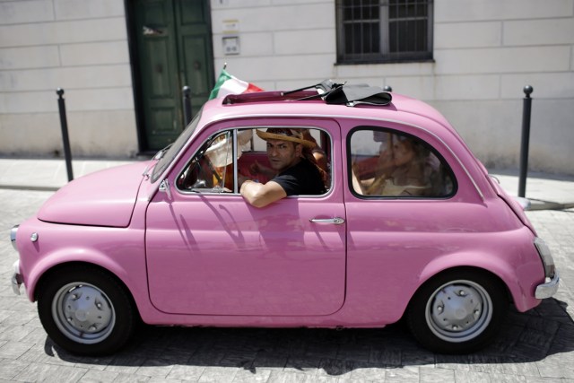 People take part at the 34th International Rally of Fiat 500 Club Italia for the 60th anniversary of this car on July 8, 2017, in Garlenda, near Genoa.   More than 1200 cars came from Europe to take part at the 34 rally of Garlenda to celebrate the 60th anniversary of the Fiat 500.  / AFP PHOTO / Marco BERTORELLO