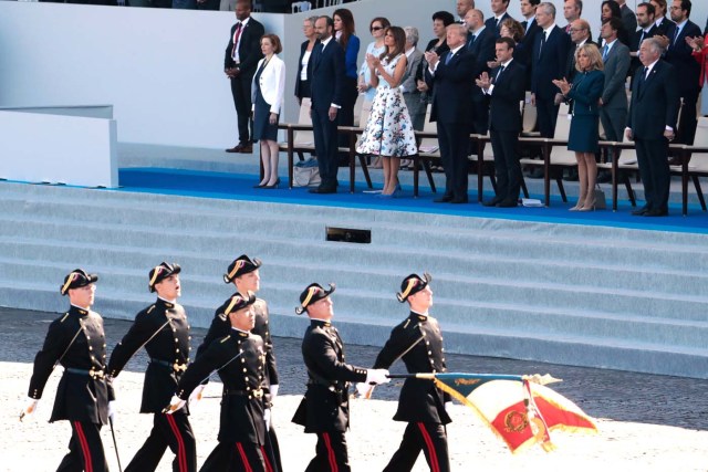 (Bottom row, from R) French President and Senate President Gerard Larcher, wife of French President Brigitte Macron, French President Emmanuel Macron, US President Donald Trump, US First Lady Melania Trump, French Prime Minister Edouard Philippe and French Defence Minister Florence Parly watch as members of the Polytechnic School (Ecole Polytechnique) march during the annual Bastille Day military parade on the Champs-Elysees avenue in Paris on July 14, 2017. The parade on Paris's Champs-Elysees will commemorate the centenary of the US entering WWI and will feature horses, helicopters, planes and troops. / AFP PHOTO / joel SAGET