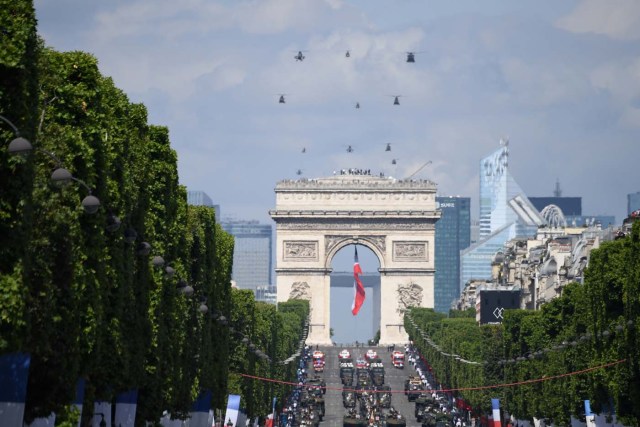 A general view shows troops and helicopters parading during the annual Bastille Day military parade on the Champs-Elysees avenue in Paris on July 14, 2017. The parade on Paris's Champs-Elysees will commemorate the centenary of the US entering WWI and will feature horses, helicopters, planes and troops. / AFP PHOTO / ALAIN JOCARD