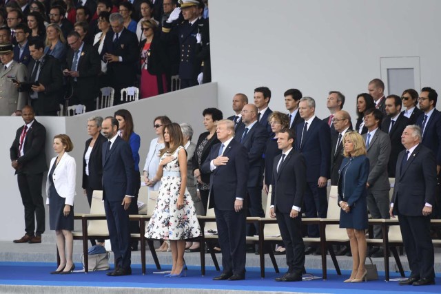 (FromL) French Defence Minister Florence Parly, French Prime Minister Edouard Philippe, US President Donald Trump and his wife First Lady Melania Trump, French President Emmanuel Macron and his wife Brigitte Macron and Senate President Gerard Larcher listen to the US national anthem during the annual Bastille Day military parade on the Champs-Elysees avenue in Paris on July 14, 2017. The parade on Paris's Champs-Elysees will commemorate the centenary of the US entering WWI and will feature horses, helicopters, planes and troops. / AFP PHOTO / SAUL LOEB