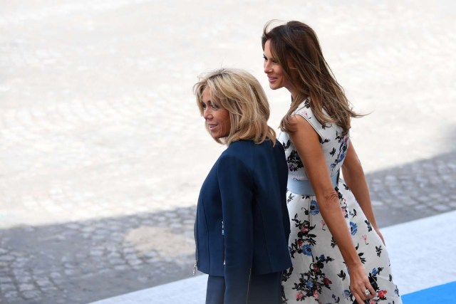 Brigitte Macron, wife of French President, (L) and US First Lady Melania Trump stand during the annual Bastille Day military parade on the Champs-Elysees avenue in Paris on July 14, 2017. The parade on Paris's Champs-Elysees will commemorate the centenary of the US entering WWI and will feature horses, helicopters, planes and troops. / AFP PHOTO / ALAIN JOCARD