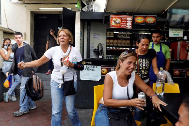 People react at a restaurant after smoke from tear gas fired by security forces got inside of it during clashes at a rally against Venezuelan President Nicolas Maduro's government in Caracas, Venezuela, July 6, 2017. REUTERS/Andres Martinez Casares