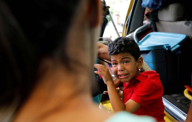 A child cries as he gets medical attention outside a shopping mall after smoke from tear gas fired by security forces got inside of it during clashes at a rally against Venezuelan President Nicolas Maduro's government in Caracas, Venezuela, July 6, 2017. REUTERS/Carlos Garcia Rawlins