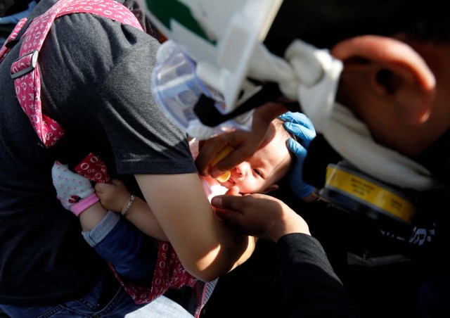 A baby gets medical attention outside a shopping mall after smoke from tear gas fired by security forces got inside of it during clashes at a rally against Venezuelan President Nicolas Maduro's government in Caracas, Venezuela, July 6, 2017. REUTERS/Carlos Garcia Rawlins