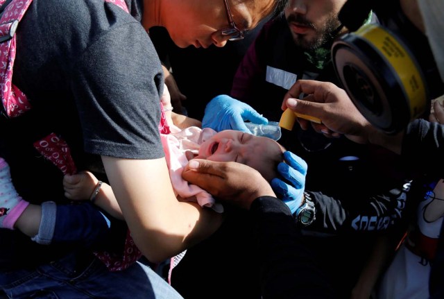 A baby gets medical attention outside a shopping mall after smoke from tear gas fired by security forces got inside of it during clashes at a rally against Venezuelan President Nicolas Maduro's government in Caracas, Venezuela, July 6, 2017. REUTERS/Carlos Garcia Rawlins