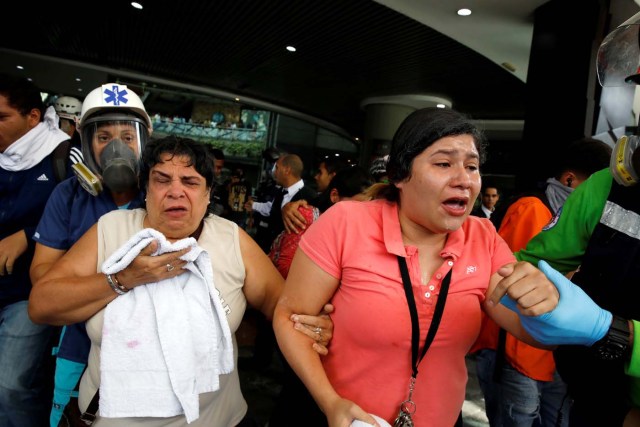 People leave a shopping mall after smoke from tear gas fired by security forces got inside of it during clashes at a rally against Venezuelan President Nicolas Maduro's government in Caracas, Venezuela, July 6, 2017. REUTERS/Carlos Garcia Rawlins