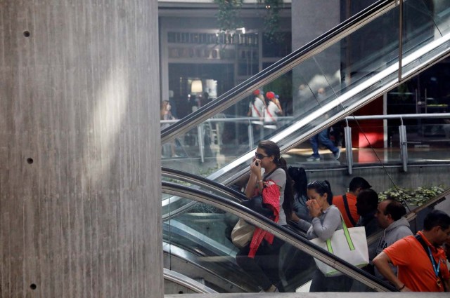 People cover their faces from tear gas inside a shopping mall as clashes between demonstrators and security forces occur on the streets during a rally against Venezuelan President Nicolas Maduro's government in Caracas, Venezuela, July 6, 2017. REUTERS/Andres Martinez Casares