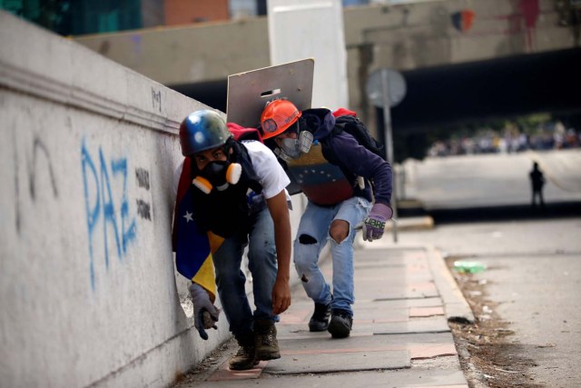 Demonstrators take cover during clashes with security forces at a rally against Venezuelan President Nicolas Maduro's government in Caracas, Venezuela, July 6, 2017. REUTERS/Andres Martinez Casares