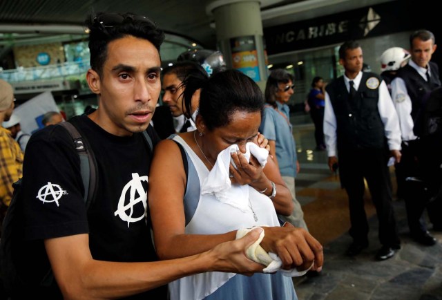 People leave a shopping mall after smoke from tear gas fired by security forces got inside of it during clashes at a rally against Venezuelan President Nicolas Maduro's government in Caracas, Venezuela, July 6, 2017. REUTERS/Carlos Garcia Rawlins