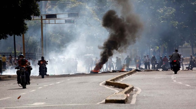 Demonstrators build a barricade as others ride their motorcycles during a rally against Venezuelan President Nicolas Maduro's government in Caracas, Venezuela, July 6, 2017. REUTERS/Carlos Garcia Rawlins