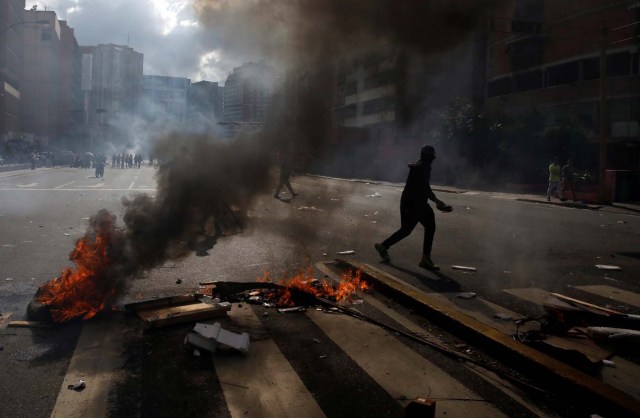 A demonstrator walks by a barricade during a rally against Venezuelan President Nicolas Maduro's government in Caracas, Venezuela, July 6, 2017. REUTERS/Carlos Garcia Rawlins