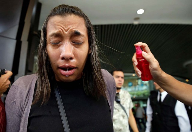 A woman has her face sprayed with water outside a shopping mall after she was affected by tear gas fired by security forces during clashes at a rally against Venezuelan President Nicolas Maduro's government in Caracas, Venezuela, July 6, 2017. REUTERS/Carlos Garcia Rawlins TPX IMAGES OF THE DAY