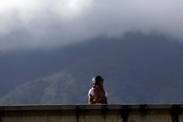 A demonstrator stands on a bridge during clashes with security forces at a rally against Venezuelan President Nicolas Maduro's government in Caracas, Venezuela, July 6, 2017. REUTERS/Marco Bello