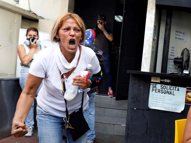 People react at a restaurant when smoke from tear gas fired by security forces got inside of it during clashes at a rally against Venezuelan President Nicolas Maduro's government in Caracas, Venezuela, July 6, 2017. REUTERS/Andres Martinez Casares