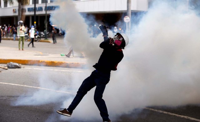 A demonstrator throws back a tear gas canister during clashes with security forces at a rally against Venezuelan President Nicolas Maduro's government in Caracas, Venezuela, July 6, 2017. REUTERS/Andres Martinez Casares