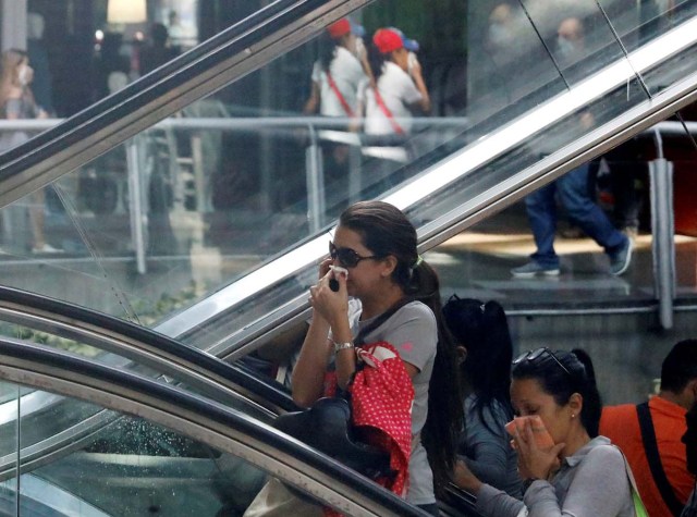 People cover their faces from tear gas inside a shopping mall as clashes between demonstrators and security forces occurred on the streets during a rally against Venezuelan President Nicolas Maduro's government in Caracas, Venezuela, July 6, 2017. REUTERS/Andres Martinez Casares