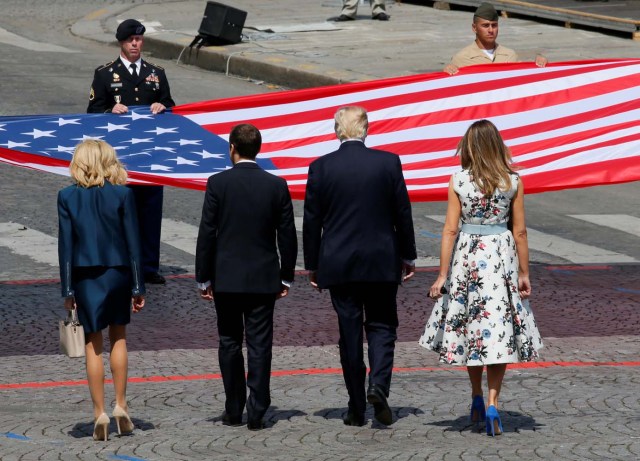 French President Emmanuel Macron, his wife Brigitte Macron, U.S. President Donald Trump and First Lady Melania Trump stand in front of the American flag at the end of the traditional Bastille Day military parade on the Champs-Elysees in Paris, France, July 14, 2017. REUTERS/Gonzalo Fuentes