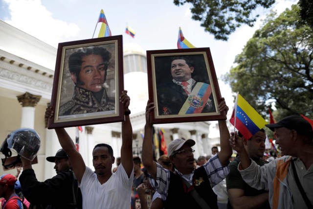 Supporters of Venezuela's President Nicolas Maduro's government hold pictures of late Venezuela's President Hugo Chavez and Venezuela's national hero Simon Bolivar as they demonstrate before the first session of the constituent assembly in Caracas, Venezuela August 4, 2017. REUTERS/Ueslei Marcelino