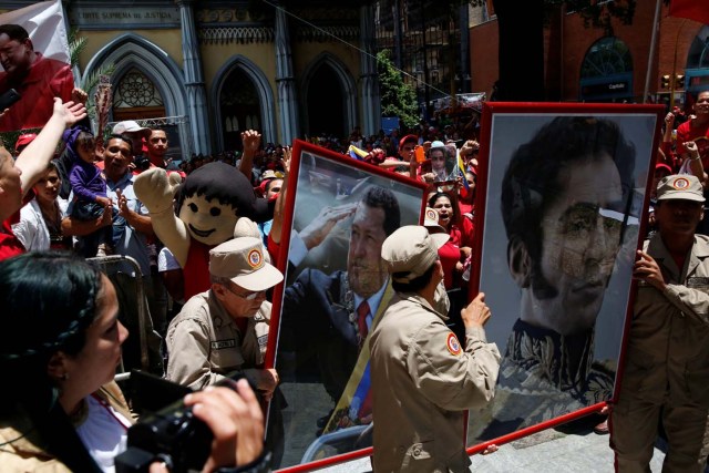 Members of the militia carry a picture of Venezuela's late President Hugo Chavez and Venezuela's national hero Simon Bolivar outside Palacio Federal Legislativo during the National Constituent Assembly's first session, in Caracas, Venezuela August 4, 2017. REUTERS/Carlos Garcia Rawlins