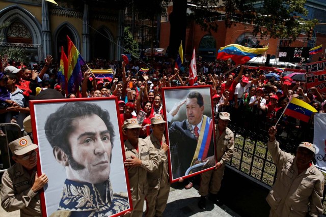 Members of the militia carry a picture of Venezuela's late President Hugo Chavez and Venezuela's national hero Simon Bolivar outside Palacio Federal Legislativo during the National Constituent Assembly's first session, in Caracas, Venezuela August 4, 2017. REUTERS/Carlos Garcia Rawlins
