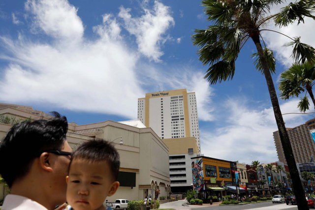 A South Korean tourist carries his child in the Tumon tourist district on the island of Guam, a U.S. Pacific Territory, August 10, 2017. REUTERS/Erik De Castro