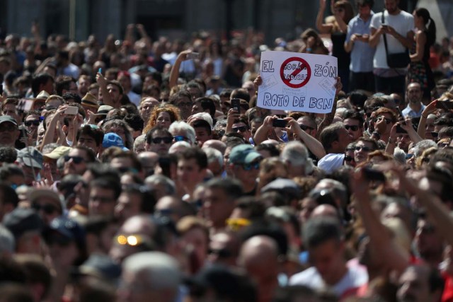 A banner is held above the crowd as people observe a minute of silence in Placa de Catalunya, a day after a van crashed into pedestrians at Las Ramblas in Barcelona, Spain August 18, 2017. REUTERS/Sergio Perez