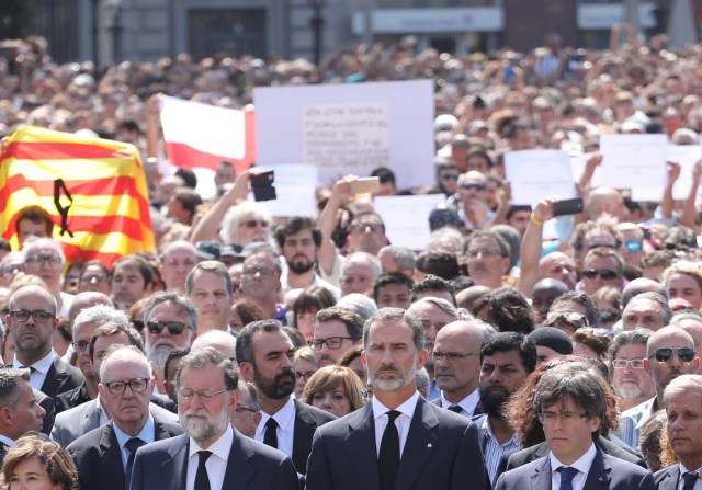 King Felipe of Spain sits between Prime Minister Mariano Rajoy and President of the Generalitat of Catalonia Carles Puigdemont as they observe a minute of silence in Placa de Catalunya, a day after a van crashed into pedestrians at Las Ramblas in Barcelona, Spain August 18, 2017. REUTERS/Sergio Perez