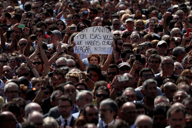En la imagen, una mujer sostiene un cartel que dice "Hoy canto por esas voces que habéis osado apagar. No tenemos miedo", durante minuto de silencio en la Plaza de Catalunya, Barcelona, España, 18 de agosto de 2017. REUTERS/Susana Vera