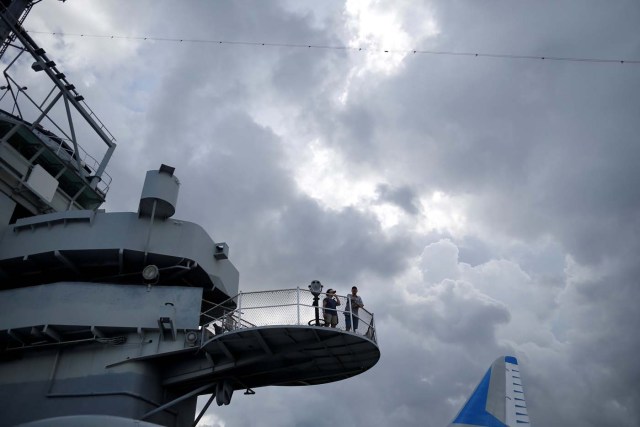 People check out the skies from an observation deck on the Naval museum ship U.S.S. Yorktown before festivities start for the Great American Eclipse in Mount Pleasant, South Carolina, U.S. August 21, 2017. Location coordinates for this image are 32º47'26" N 79º54'31" W. REUTERS/Randall Hill
