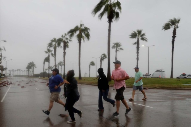 A group of people race across the street as winds from Hurricane Harvey escalated in Corpus Christi, Texas, U.S. August 25, 2017. REUTERS/Adrees Latif