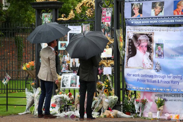 Britain's Prince William, Duke of Cambridge and Prince Harry look at flowers and tributes left in memory of the late Princess Diana at the gates of her former residence Kensington Palace in London, Britain, August 30, 2017. REUTERS/Hannah McKay NO RESALES. NO ARCHIVES