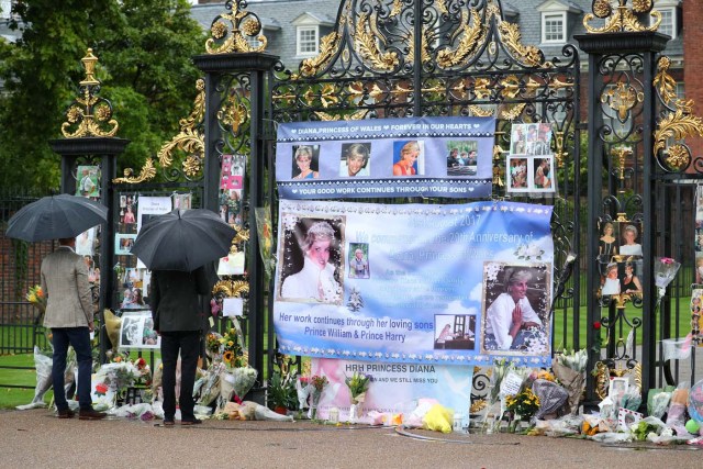 Britain's Prince William, Duke of Cambridge and Prince Harry look at flowers and tributes left in memory of the late Princess Diana at the gates of her former residence Kensington Palace in London, Britain, August 30, 2017. REUTERS/Hannah McKay NO RESALES. NO ARCHIVES