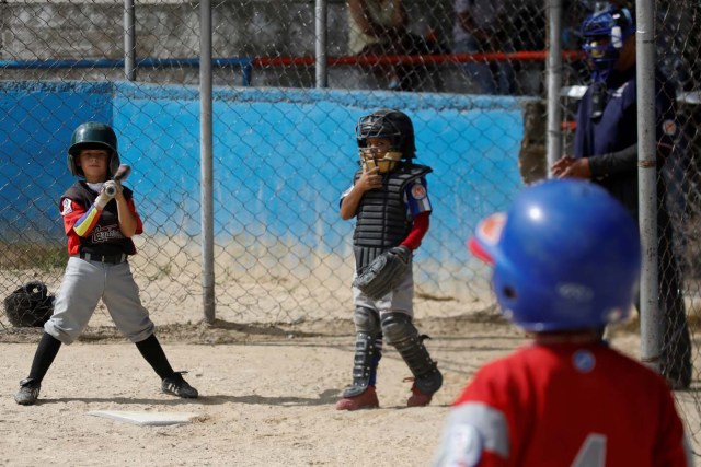 Jeanpierre Fonseca (L) prepares to bat during a baseball championship in Caracas, Venezuela August 24, 2017. Picture taken August 24, 2017. REUTERS/Carlos Garcia Rawlins