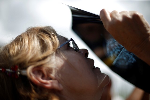 A woman uses an X-ray to watch a partial solar eclipse at the Venezuelan Institute for Scientific Research (IVIC) in San Antonio de los Altos, Venezuela, August 21, 2017. REUTERS/Andres Martinez Casares