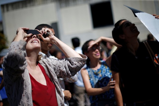 People look at a partial solar eclipse at the Venezuelan Institute for Scientific Research (IVIC) in San Antonio de los Altos, Venezuela, August 21, 2017. REUTERS/Andres Martinez Casares