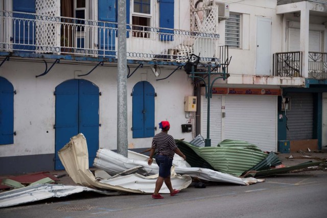 A woman walks in the streets of Marigot, on September 9, 2017 in Saint-Martin island devastated by Irma hurricane. Officials on the island of Guadeloupe, where French aid efforts are being coordinated, suspended boat crossings to the hardest-hit territories of St. Martin and St. Barts where 11 people have died. Two days after Hurricane Irma swept over the eastern Caribbean, killing at least 17 people and devastating thousands of homes, some islands braced for a second battering from Hurricane Jose this weekend. / AFP PHOTO / Martin BUREAU