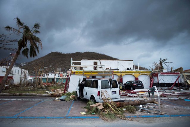 A picture shows a wrecked car in the streets of Marigot, on September 9, 2017 in Saint-Martin island devastated by Irma hurricane. Officials on the island of Guadeloupe, where French aid efforts are being coordinated, suspended boat crossings to the hardest-hit territories of St. Martin and St. Barts where 11 people have died. Two days after Hurricane Irma swept over the eastern Caribbean, killing at least 17 people and devastating thousands of homes, some islands braced for a second battering from Hurricane Jose this weekend. / AFP PHOTO / Martin BUREAU