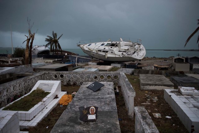 A sailing boat is beached in the cemetery of Marigot, on September 9, 2017 in Saint-Martin island devastated by Irma hurricane. Officials on the island of Guadeloupe, where French aid efforts are being coordinated, suspended boat crossings to the hardest-hit territories of St. Martin and St. Barts where 11 people have died. Two days after Hurricane Irma swept over the eastern Caribbean, killing at least 17 people and devastating thousands of homes, some islands braced for a second battering from Hurricane Jose this weekend. / AFP PHOTO / Martin BUREAU