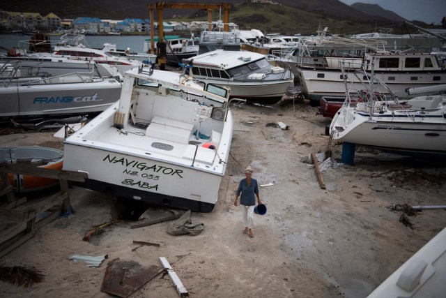 A woman walks past wrecked boats in Geminga shipyard in Marigot, on September 9, 2017 in Saint-Martin island devastated by Irma hurricane. Officials on the island of Guadeloupe, where French aid efforts are being coordinated, suspended boat crossings to the hardest-hit territories of St. Martin and St. Barts where 11 people have died. Two days after Hurricane Irma swept over the eastern Caribbean, killing at least 17 people and devastating thousands of homes, some islands braced for a second battering from Hurricane Jose this weekend. / AFP PHOTO / Martin BUREAU