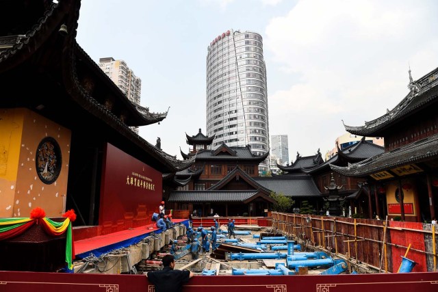 (FILES) This file picture taken on September 5, 2017 shows construction personnel working to relocate the main hall of the 135-year old Yufo Temple, also known as the Jade Buddha Temple, in Shanghai. The main hall and statues of the temple in central Shanghai have been moved 30 metres (100 feet) on rails to ease crowding at the popular site. / AFP PHOTO / Chandan KHANNA