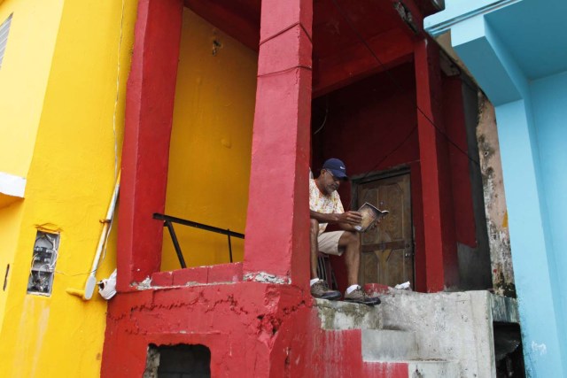 A man reads a book in the neighbourhood of La Perla in the aftermath of Hurricane Maria in San Juan, Puerto Rico, on September 22, 2017. Puerto Rico battled dangerous floods Friday after Hurricane Maria ravaged the island, as rescuers raced against time to reach residents trapped in their homes and the death toll climbed to 33. / AFP PHOTO / Ricardo ARDUENGO