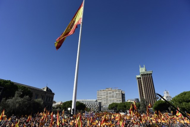 Una bandera gigante de España revolotea sobre las personas ondeando banderas españolas durante una manifestación llamando a la unidad en la Plaza de Colón en Madrid el 28 de octubre de 2017, un día después de que se impuso el control directo sobre Cataluña en un intento por separarse de España. España se movió para afirmar el dominio directo sobre Cataluña, reemplazando a sus funcionarios ejecutivos y altos para sofocar un impulso de independencia que ha sumido al país en una crisis y ha puesto nerviosa a la Europa secesionista. / AFP PHOTO / JAVIER SORIANO