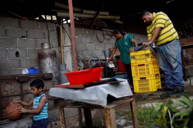 Medical equipment repairman Leandro Colmenares (R) makes corn dough at the backyard of his house in Caracas, Venezuela October 3, 2017. Picture taken October 3, 2017. REUTERS/Carlos Garcia Rawlins