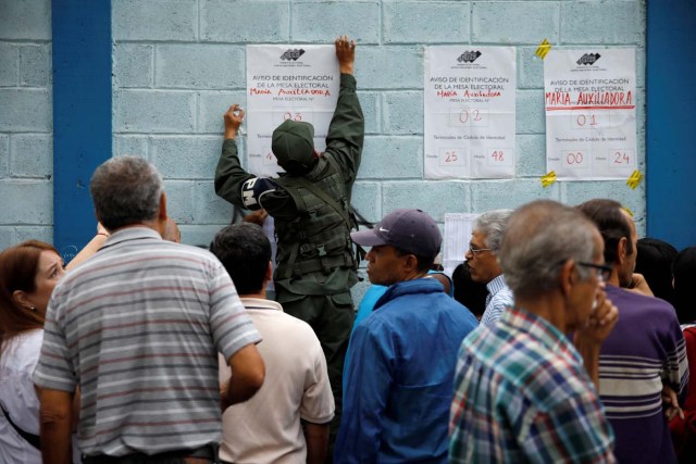Venezuela's citizens check a list in a polling station during a nationwide election for new governors, in Caracas, Venezuela, October 15, 2017. REUTERS/Carlos Garcia Rawlins