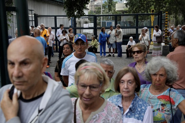 Los ciudadanos de Venezuela esperan emitir sus votos en una mesa de votación durante una elección nacional para nuevos gobernadores en Caracas, Venezuela, el 15 de octubre de 2017. REUTERS / Ricardo Moraes