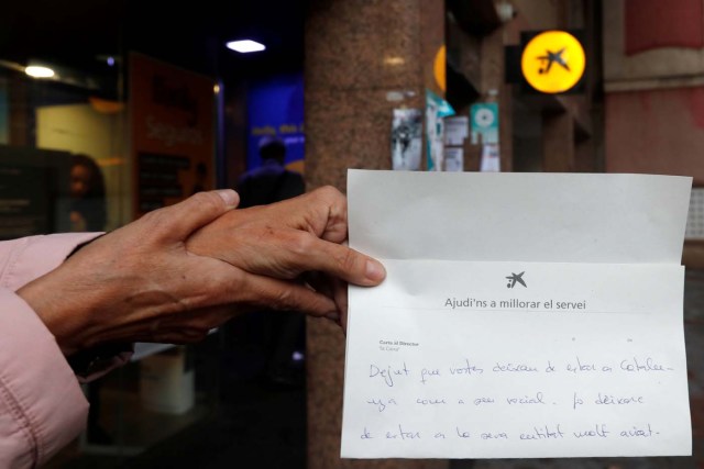 A woman shows a complaint letter addressed to La Caixa bank, to protest the transfer of the bank's headquarters out of Barcelona, Spain, October 20, 2017. REUTERS/Gonzalo Fuentes