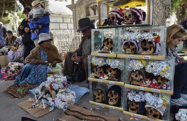 Devotees spend time at the Central Cemetery of La Paz with their "natitas" (snub-nosed) human skulls during the annual traditional ritual on November 8, 2017. The "natitas" are meant to protect their owners, who keep them at home all year long and bring them to the cemetery chapels every November 8 to perform rituals which end up in a traditional party. / AFP PHOTO / Aizar RALDES