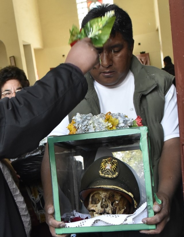 A devotee has his "natita" (snub-nosed) human skull blessed at the Central Cemetery's chapel in La Paz, during the annual traditional ritual on November 8, 2017. The "natitas" are meant to protect their owners, who keep them at home all year long and bring them to the cemetery chapels every November 8 to perform rituals which end up in a traditional party. / AFP PHOTO / Aizar RALDES