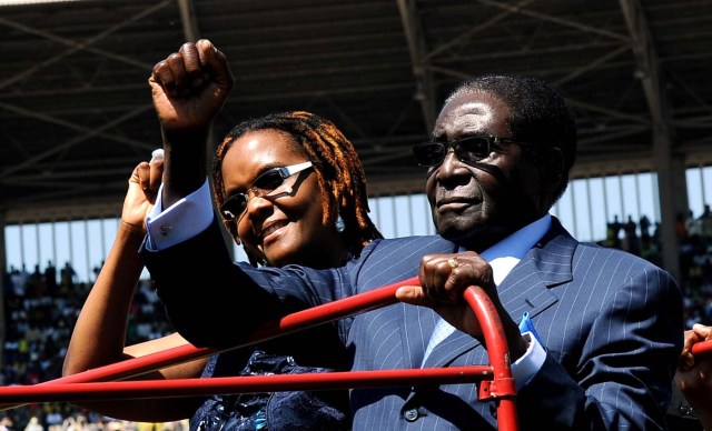 (FILES) This file photo taken on August 22, 2013 shows Zimbabwean President Robert Mugabe (R), accompanied by wife Grace, raising his fist as he greets the crowd at his inauguration ceremony in Harare at the National 60,000-seat sports stadium. Zimbabwe's military appeared to be in control of the country on November 15, 2017 as generals denied staging a coup but used state television to vow to target "criminals" close to President Robert Mugabe. Mnangagwa's dismissal left Mugabe's wife Grace, 52, in prime position to succeed her husband as the next president -- a succession strongly opposed by senior ranks in the military. / AFP PHOTO / ALEXANDER JOE
